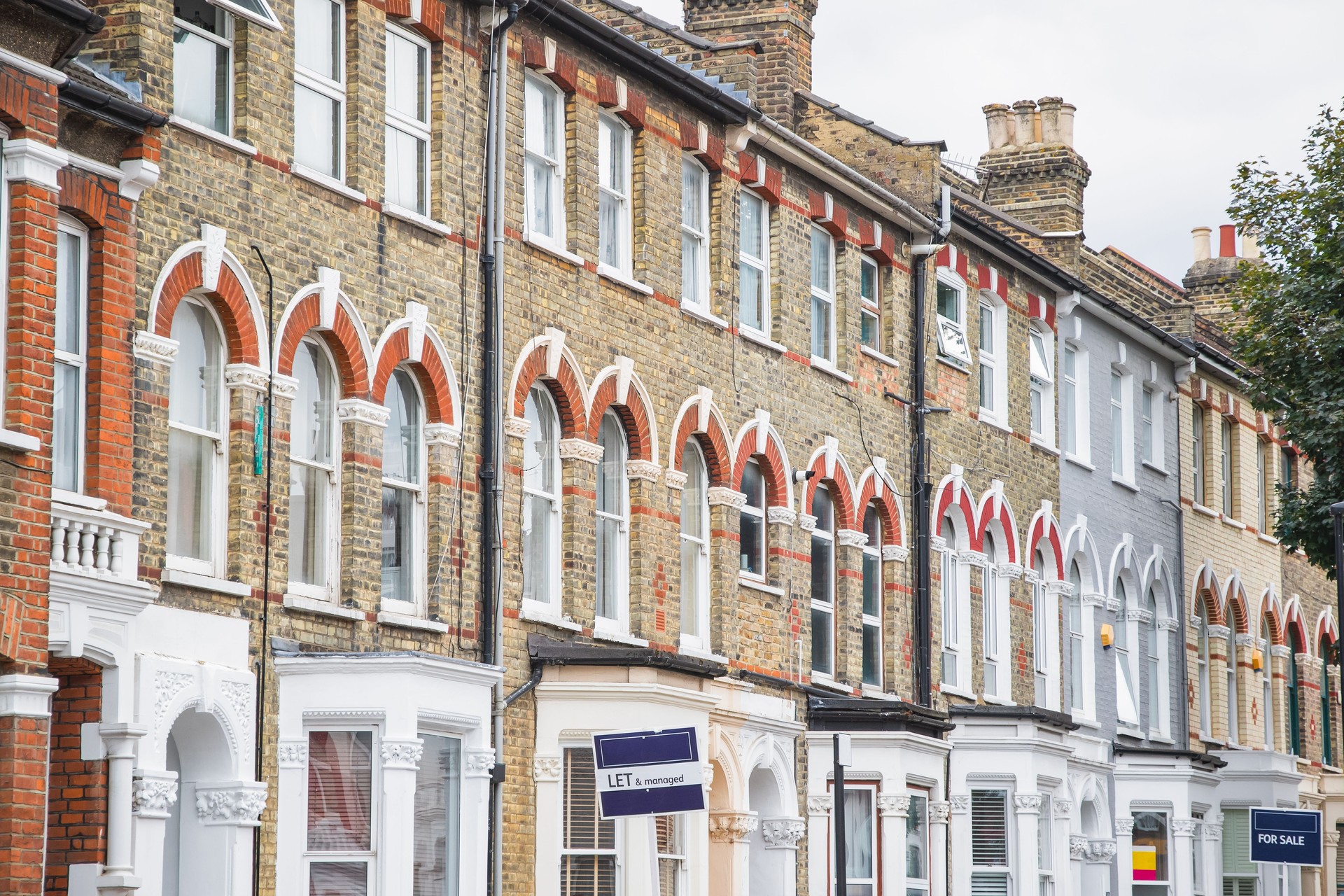 Estate agent signs displayed outside terraced houses in Harringay Ladder area, London