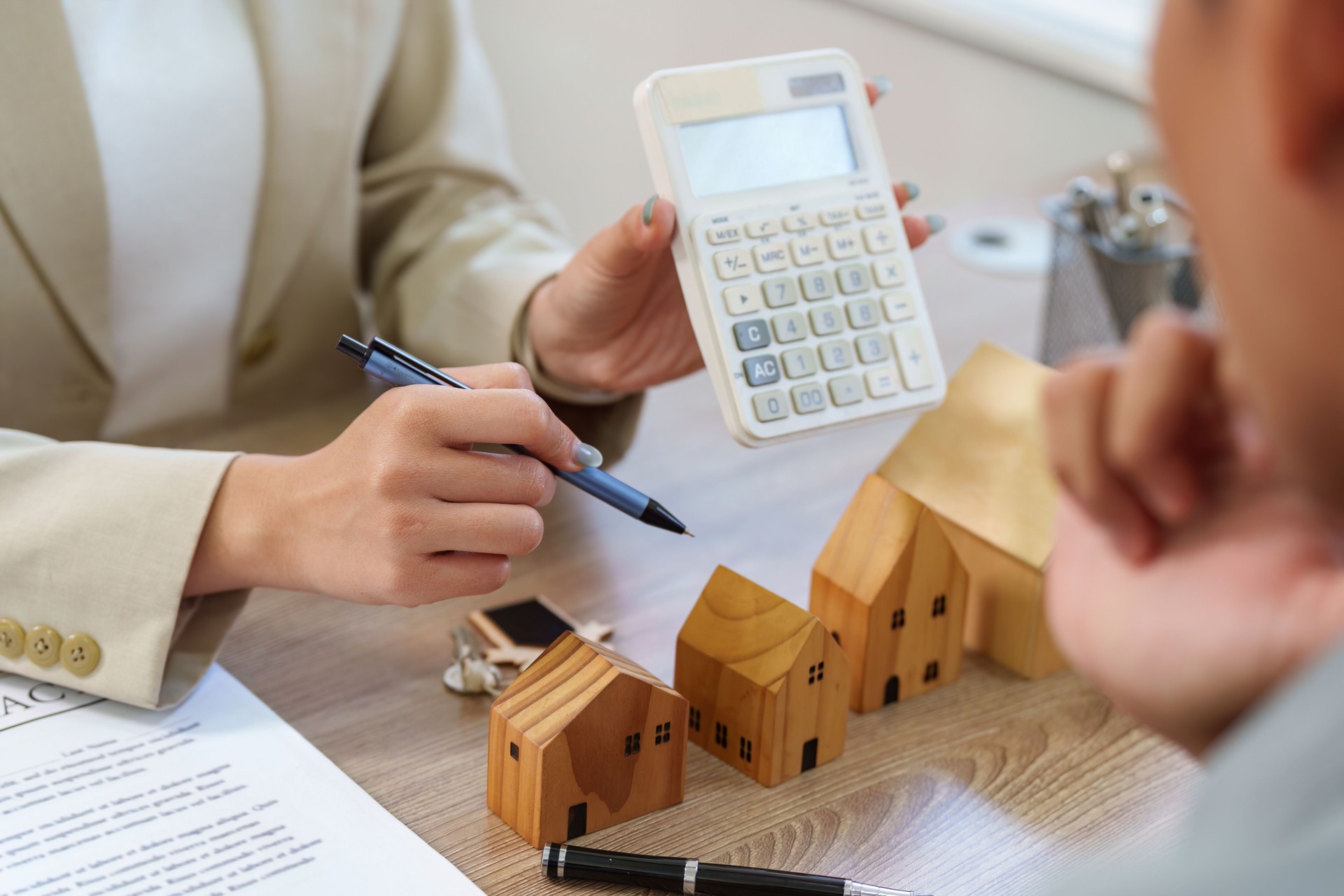 Real Estate Agent Using Calculator to Discuss Finances