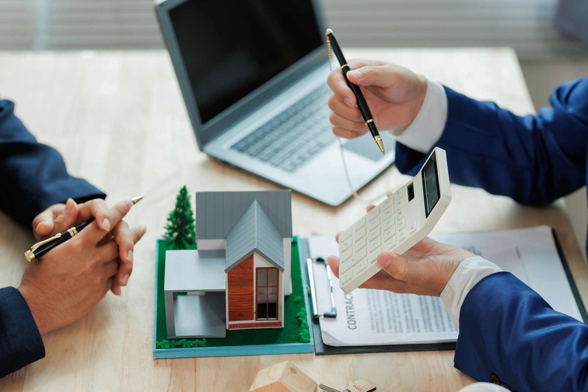 A real estate agent assists a client by calculating mortgage rates and monthly payments, helping them understand their home financing options.